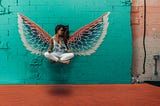 Woman levitating foreground. Angle wings graphic in background.