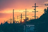 Sunset in the suburbs over power lines.