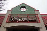 The front entrance of the Walt Whitman rest stop on the New Jersey Turnpike. The sign is Walt Whitman’s name in pink and green 90’s neon.