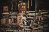 Multiple piles of books on top of a table.