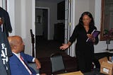 Dominic Carter sitting listening as his daughter Courtney Carter speaks at a public event focused on child advocacy, resilience, and community support.