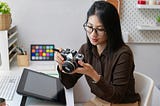 A woman looking at a camera in her home studio.