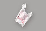 White plastic grocery bag with red “thank you” text on gray background