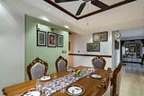A tastefully designed dining room with a table and a ceiling fan, showcasing elegant home interior design.