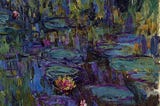 Claude Monet’s 1917 oil painting Water Lilies, depicting an abstracted pond surface filled with overlapping green lily pads and a few pink and yellow blossoms, rendered in thick, swirling strokes of blue, green, and purple that blur water, reflections, and plants into a single shimmering field.