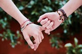 holding hands, wearing friendship bracelets