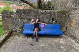 Young woman in a beautiful blue park bench with a pink heart, in Melgaço — Portugal