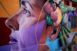 Street Art Grafitti showing the profile of a woman wearing a nose ring and flowers behind her ear