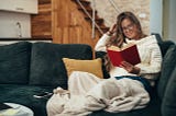 Woman reading a book while relaxing on sofa