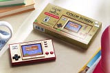 A Super Mario Bros Game and Watch handheld with a retro case referencing the old school boxes of the 80s