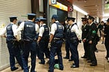 A group of Japanese police subduing a suspect