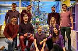 The Beining & Bogen team posing in front of a christmas tree at the office.
