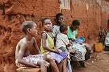 A family of five sits outside of their home in Togo