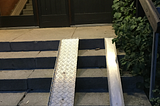 ramp installed besides a small staircase at the gateway of an apartment building