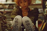 Rapper Ice Spice sitting on with her shoes on the counter.