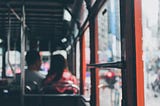 Photo from inside a bus looking out of the window into a city