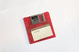 Red floppy disk with 12/11/03 written on it