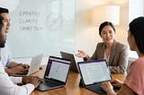 Manager leading a digital team with empathy during a virtual meeting on laptops and video screens