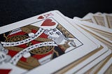 A deck of playing cards with only a King of Hearts revealed facing up on top.