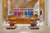 Hermes store with rack of colorful clothes and emblem on the floor