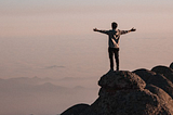 standing on the summit embracing new life choices with arms spread wide