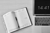 flat-lay-photography-of-unfold-book-beside-macbook