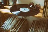 Vinyl disc on top shelf with record collection