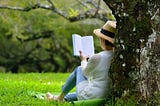 Lady reading by a tree