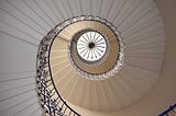 A spiral staircase suggestive of depth as the spiral reaches to roof