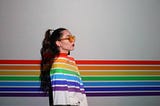 Teen girl with a rainbow running behind her and over her sweater.