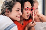 Three women standing close together and posing for the camera.