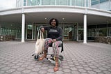 Dark skinned Black woman sitting on a wheelchair