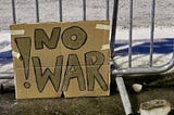 A protest sign reading ‘no war’