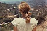 A young woman overlooking a dry valley in California