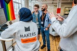 A goup og learners around smiling and looking at a computer screen