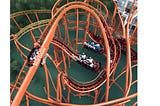A large loopy roller coaster with three cars on the tracks.