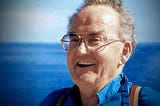 Smiling older man with glasses on the ocean