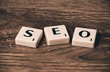 Scrabble  blocks spelling out “SEO” on a wooden table