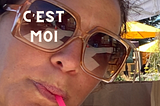 photo of author in sunglasses, sipping from a straw. On top of one of the lenses says “C’est moi”