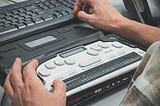 Blind man using a braille screen reader.