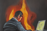 Man sitting at a laptop on fire.