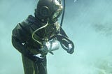 Person in Old School Green Scuba Diving Suit
