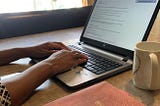 Picture of the Author, Writing, well typing on her laptop. Photo was taken by Author’s Son