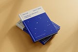 Mockup of two books, one on top of the other. On the top is ‘Clean Code’ by Robert C. Martin. It showcases the cover, redesigned by María Simó, on cream and electric blue tones and some dots resembling pixels or constellations.