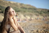 A woman sunbathing on a beach.