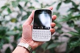 Blackberry phone held in a hand.