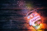 lighted open glass jar with word Dreams