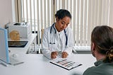 Doctor with her patient. Photo by Cottonbro on Pexels