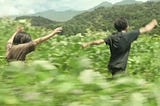 Mugino Minato dan Hoshikawa Yori berlarian bersama di padang rumput dalam cuplikan adegan film Monster (2023)