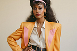 A glamorous black woman wearing 1980s clothes.